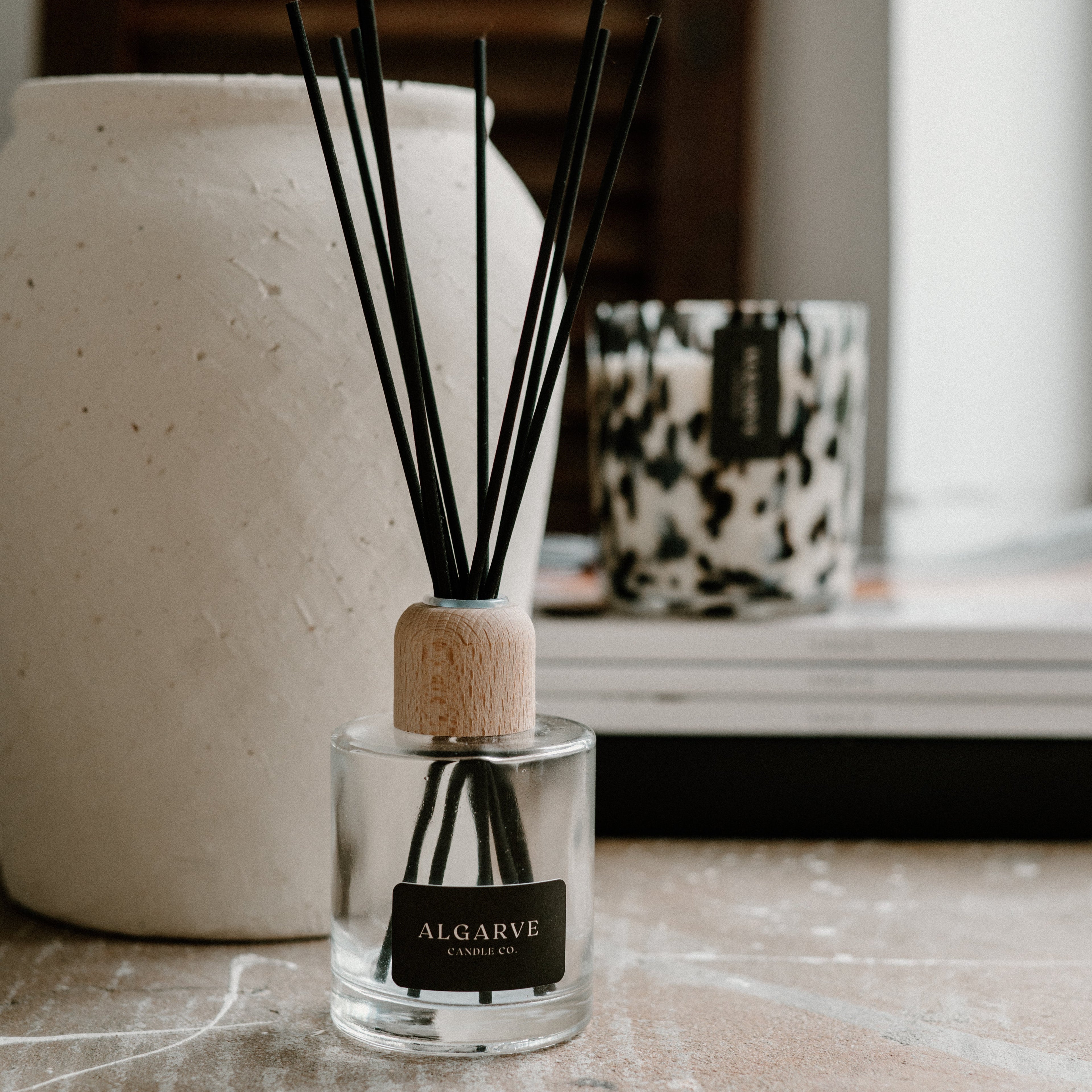 Diffuser with black reeds on a surface near a window